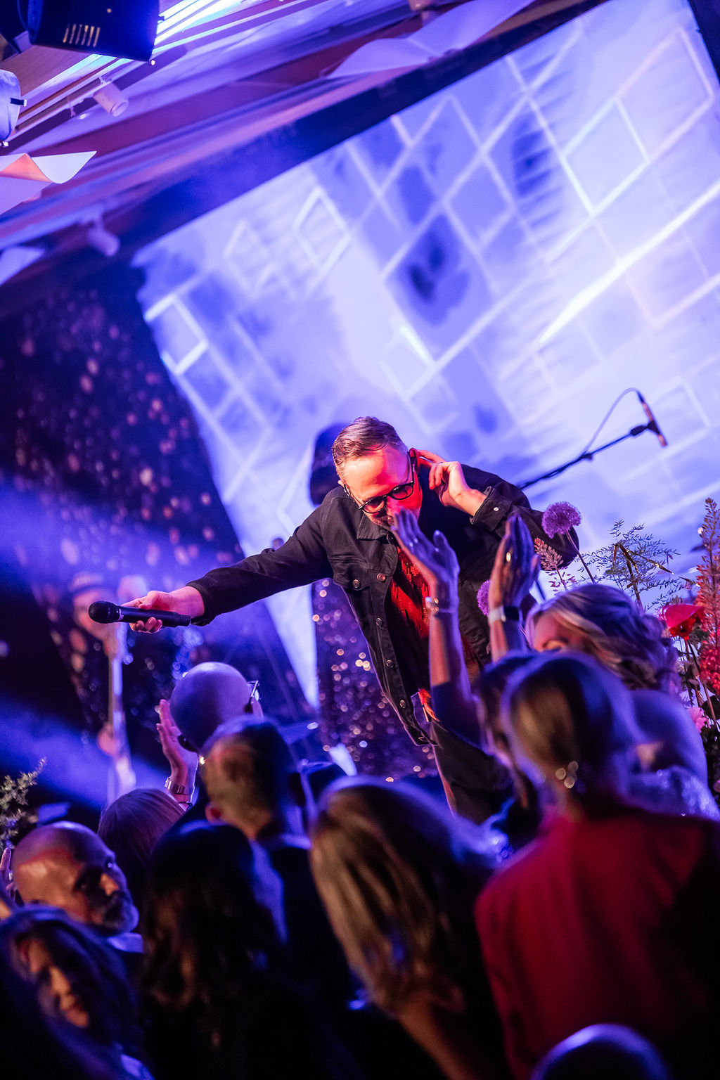 Linus Lindholm sjunger nära publiken i blått klubbljus